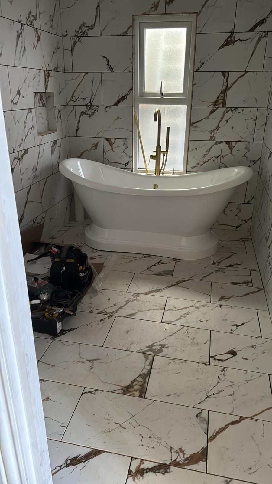 Bathroom refurbishment in progress with marble-effect panels
