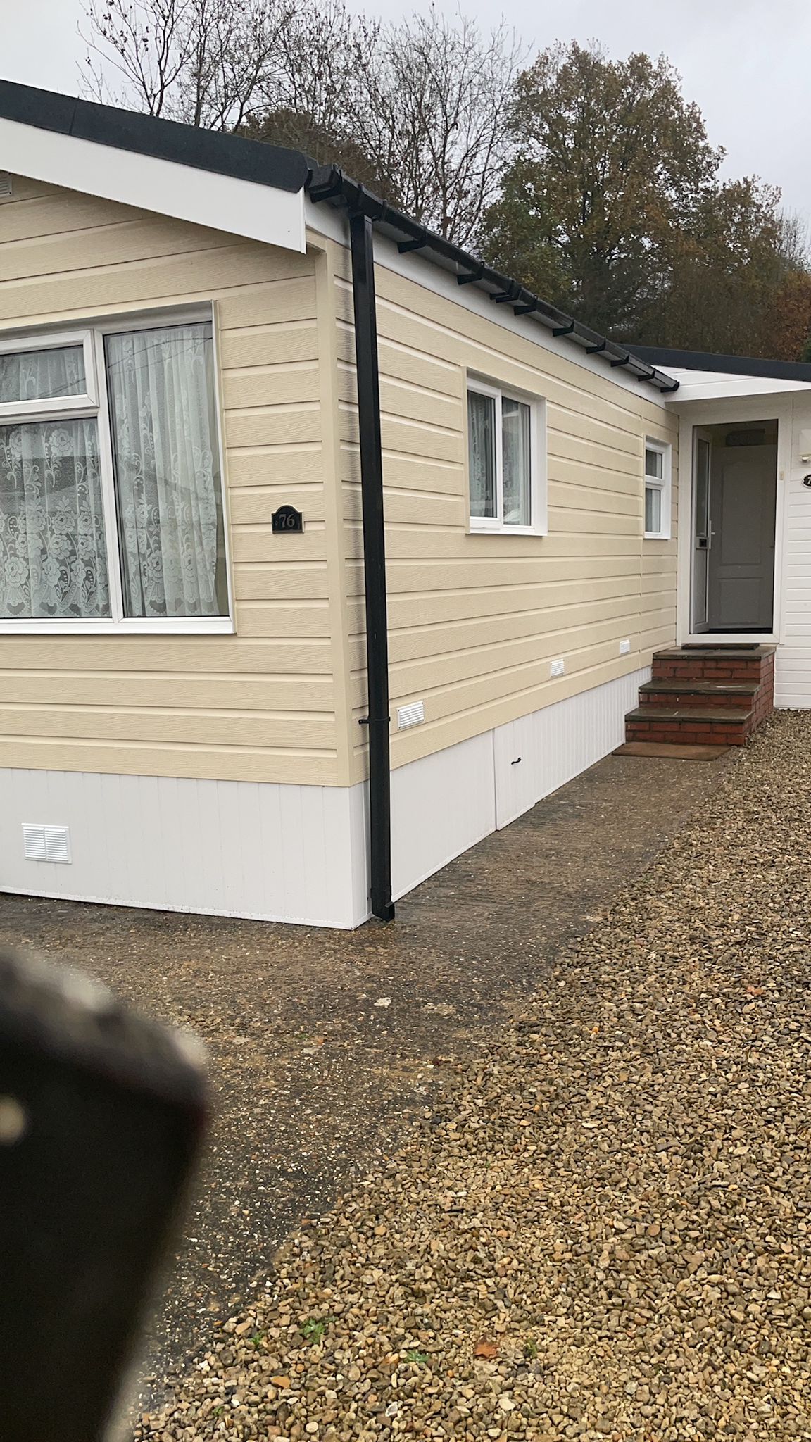 Completed cream clad park home with new black downpipe and white base trim
