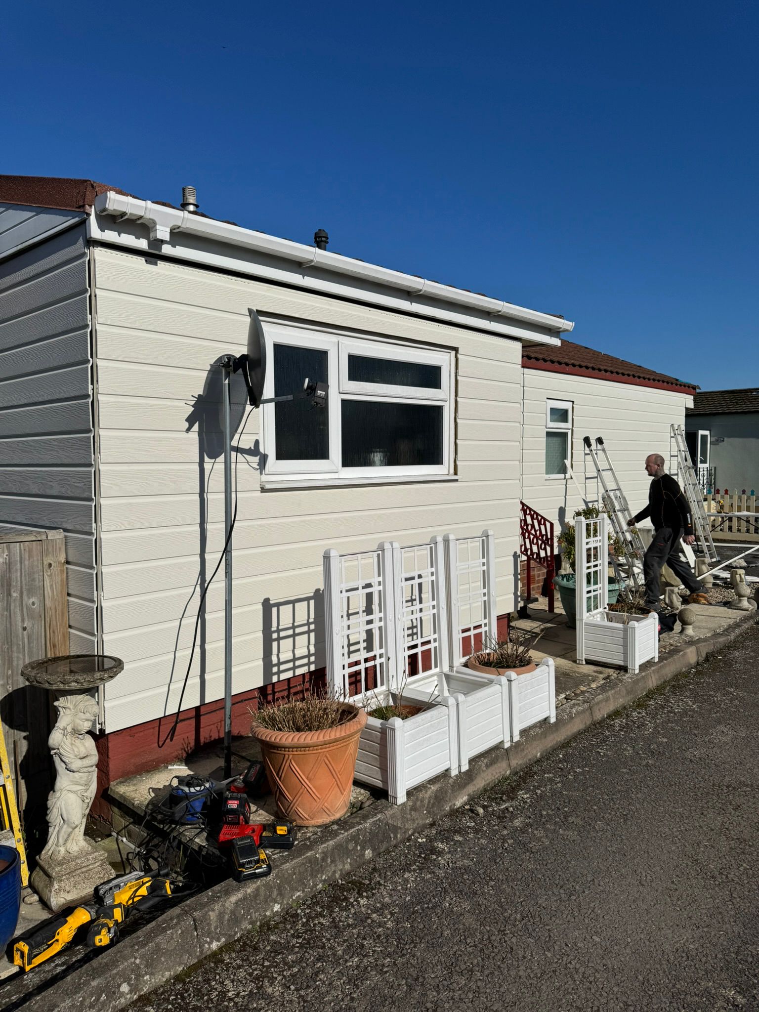 Finished cream clad park home side with fresh white fascia and guttering