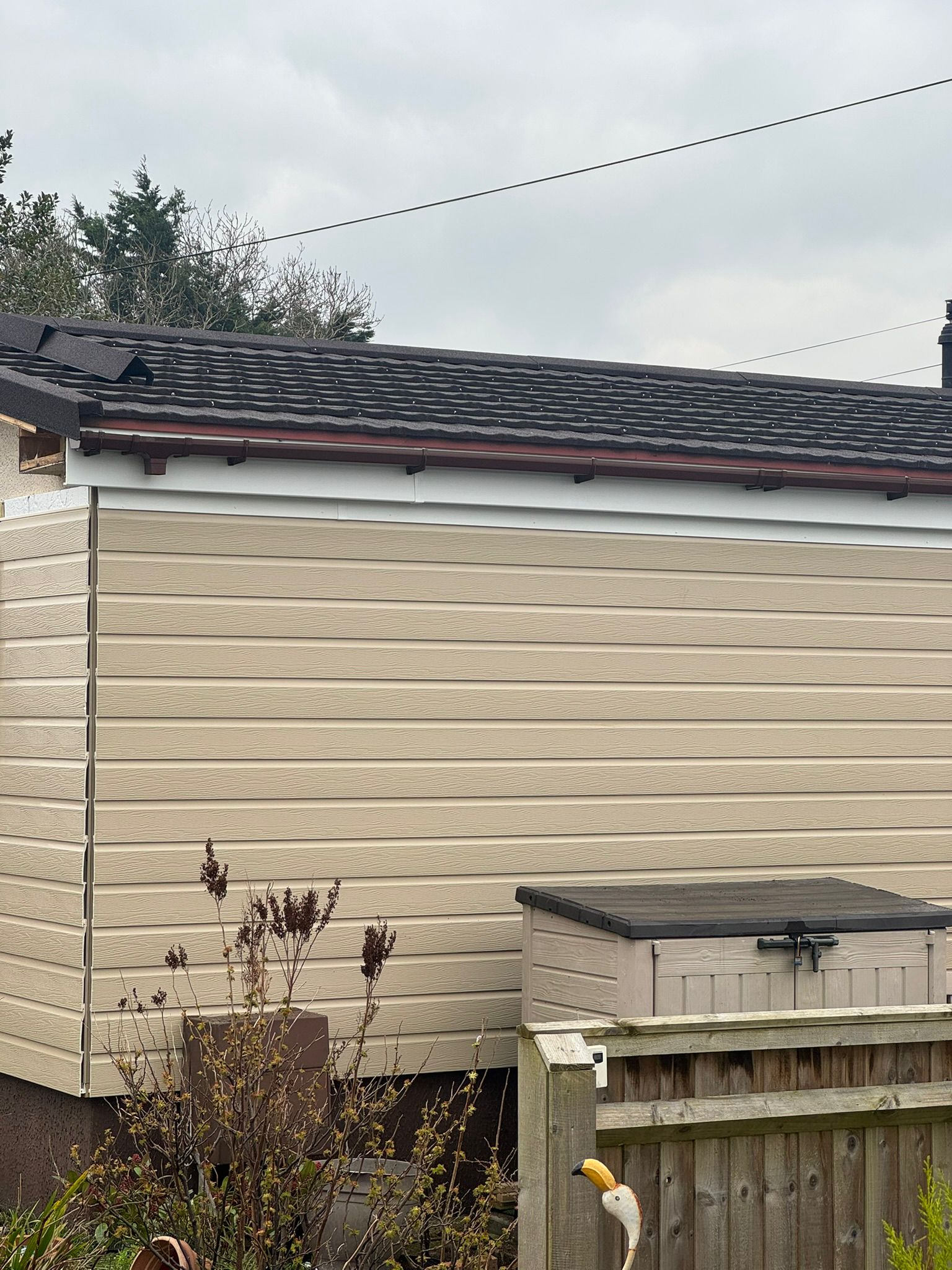 Side view of a finished park home with tan cladding and new tiled roof