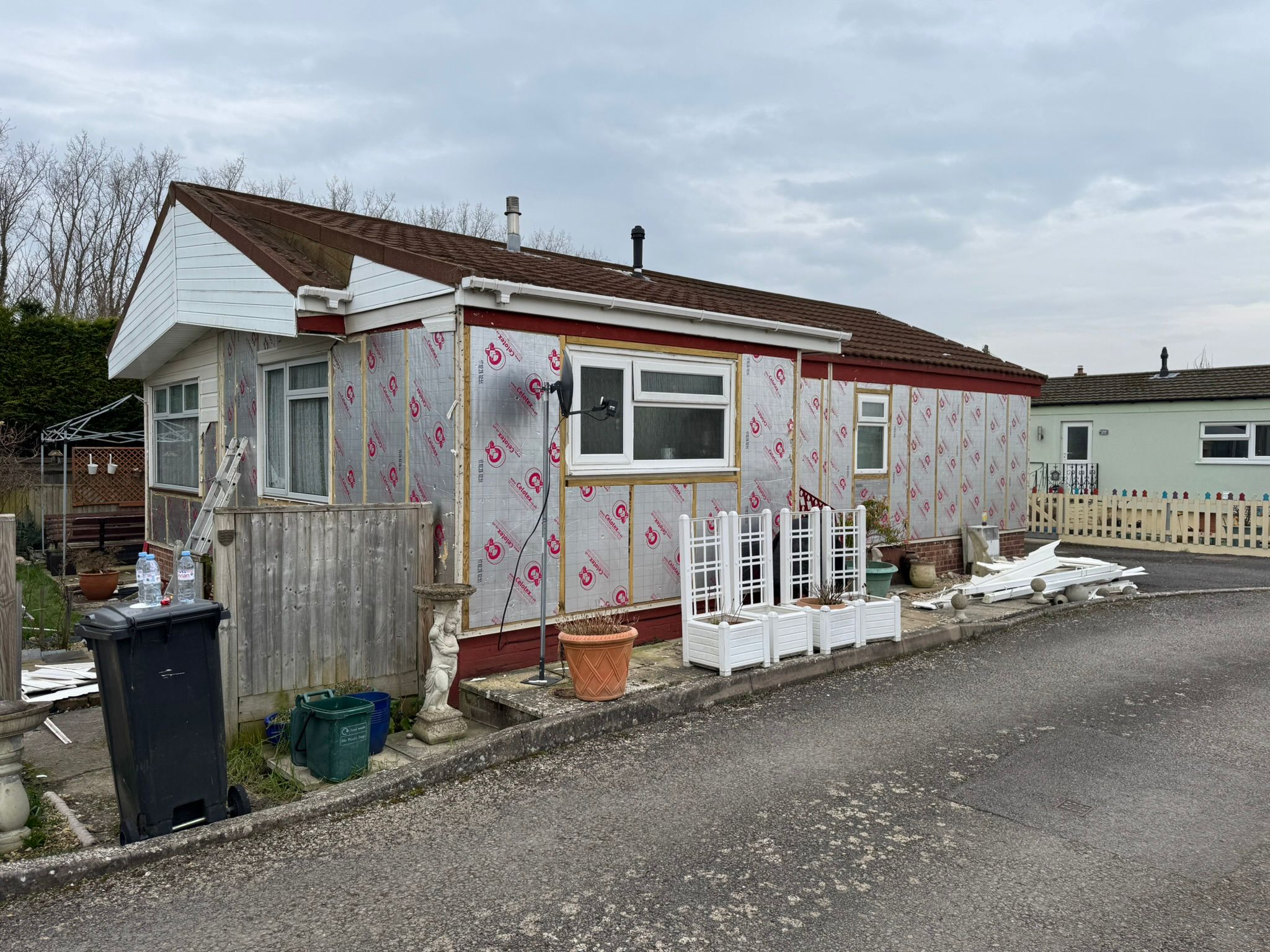 Full side of a park home wrapped in Celotex insulation boards ready for new cladding