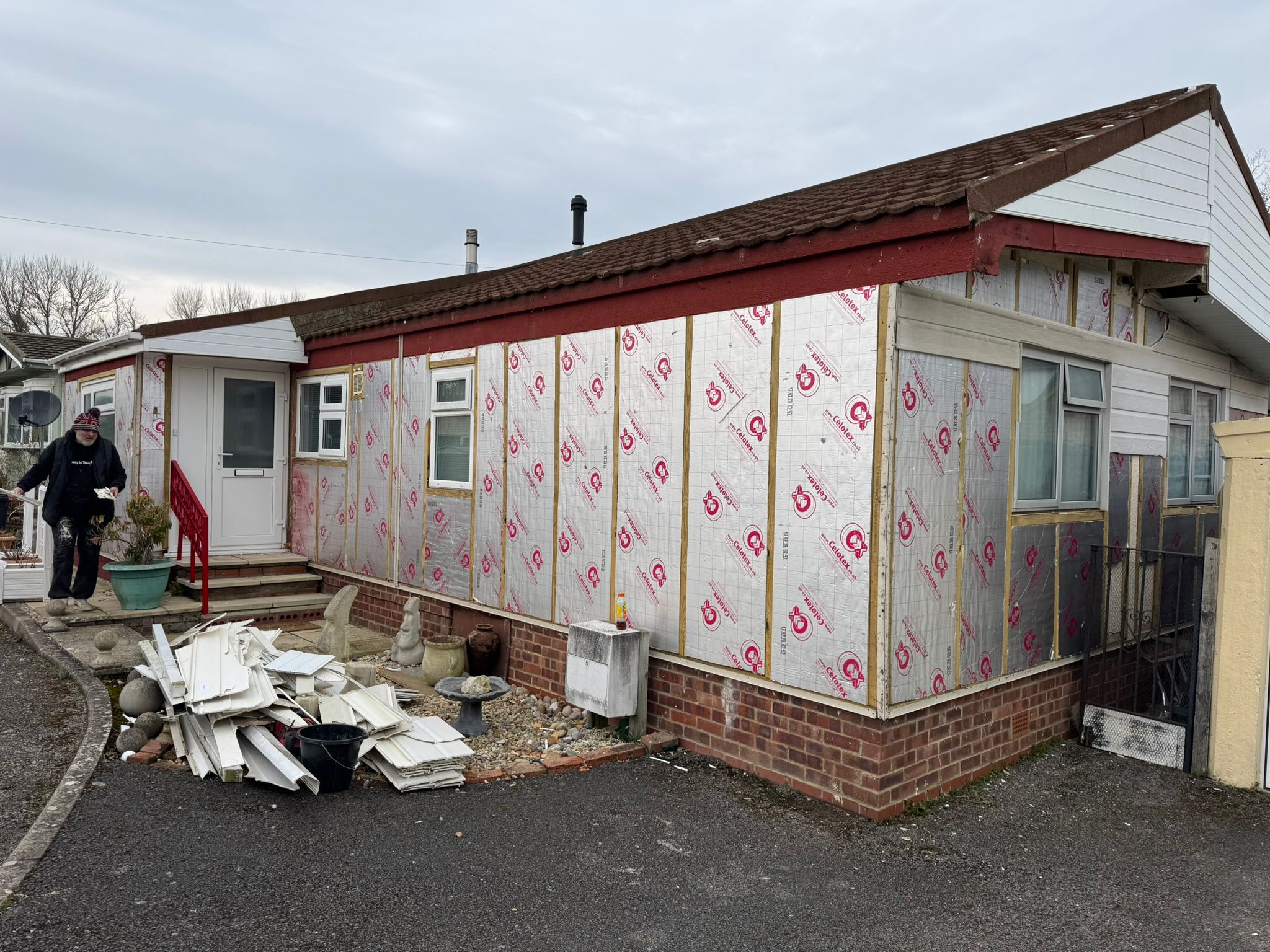 Team member preparing a Celotex-wrapped park home before re-cladding