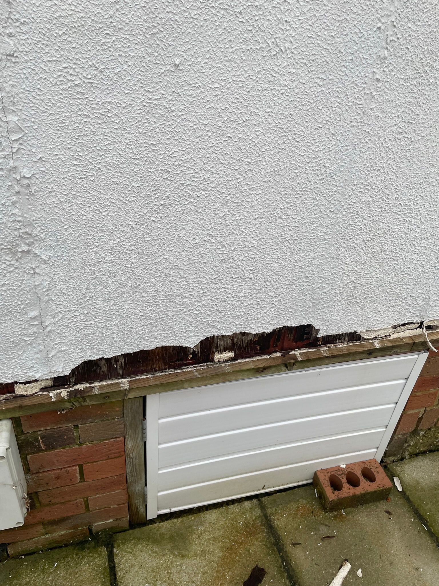 Rotten timber base rail exposed above the brick foundation before renovation