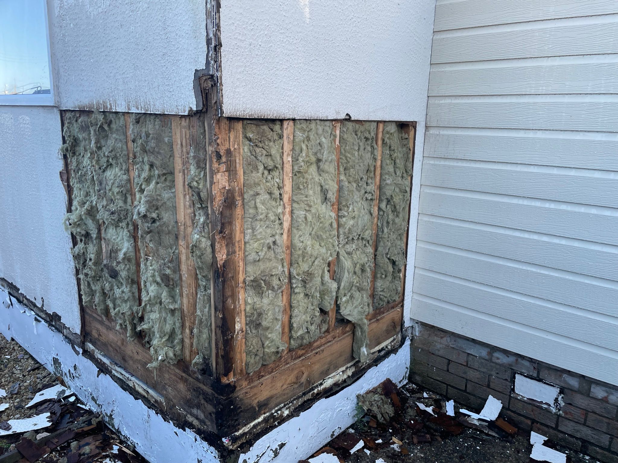Park home corner stripped back revealing rotten timber frame and old fibreglass insulation