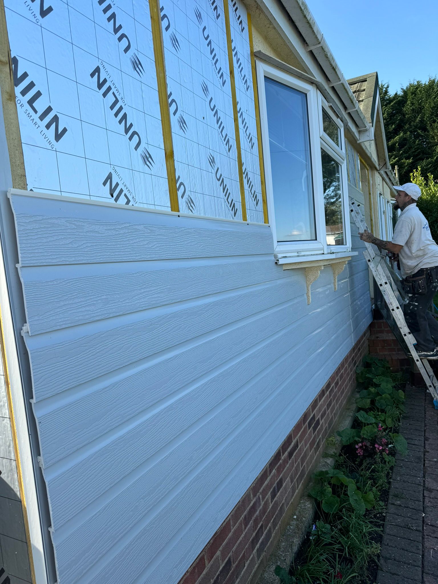 New white cladding fitted over Unilin insulation membrane