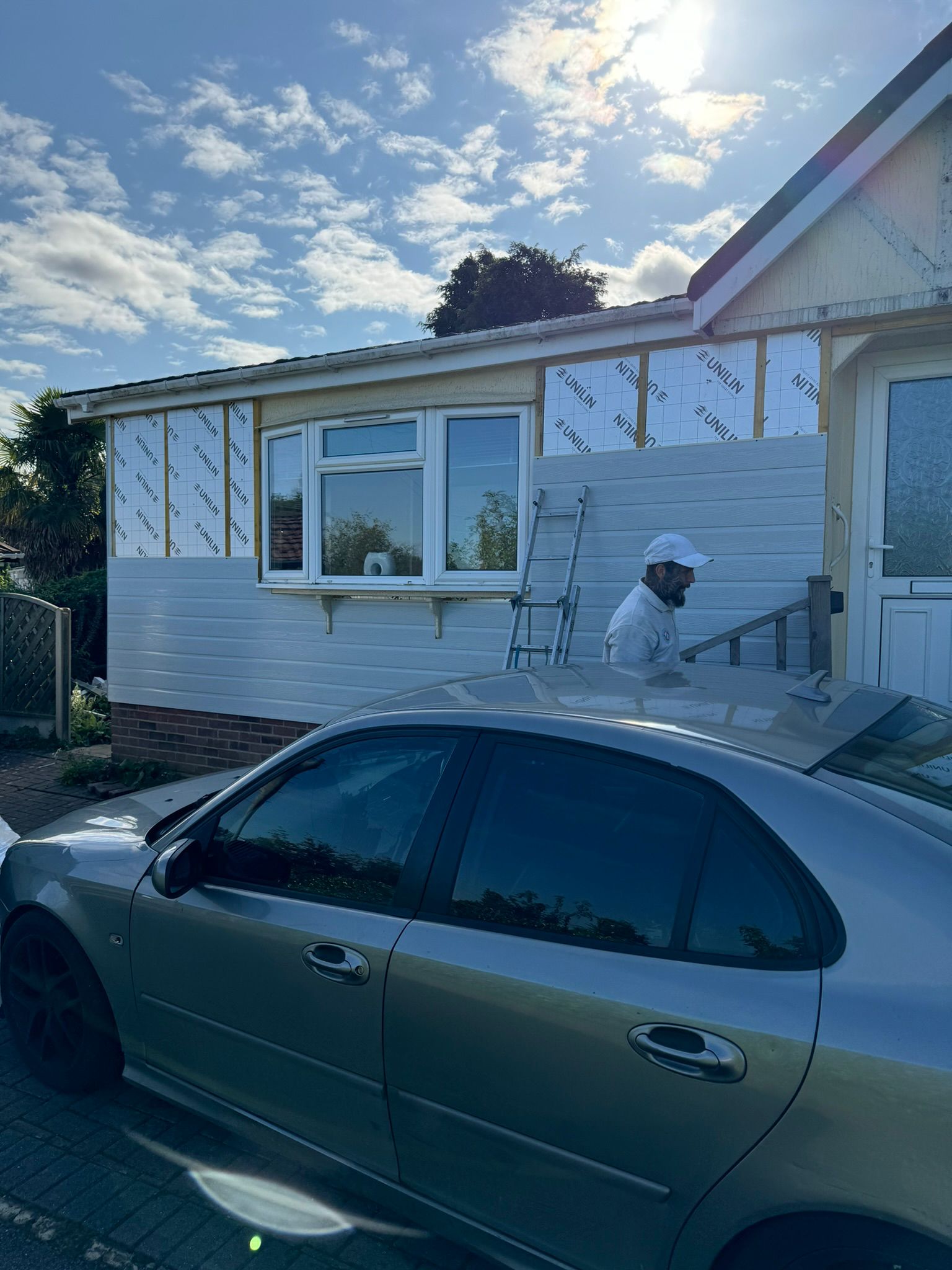 White cladding installation in progress over Unilin insulation boards